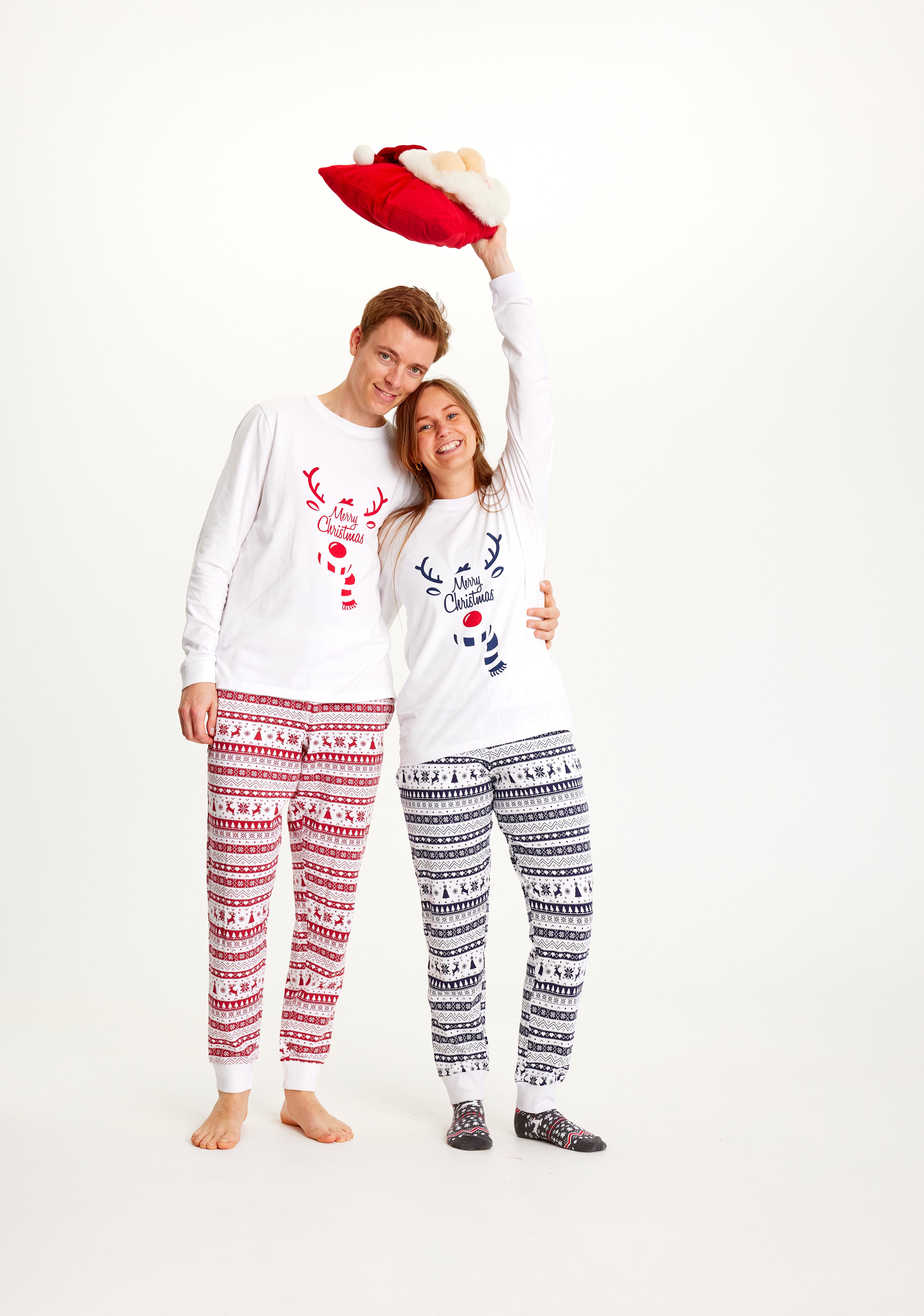 Un couple posant ensemble vêtu d'un pyjama de Noël blanc.